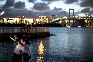 People take pictures at Odaiba Marine Park in Tokyo on August 26, 2024. (Photo by Philip FONG / AFP) (Photo by PHILIP FONGPHILIP FONG/AFP via Getty Images)